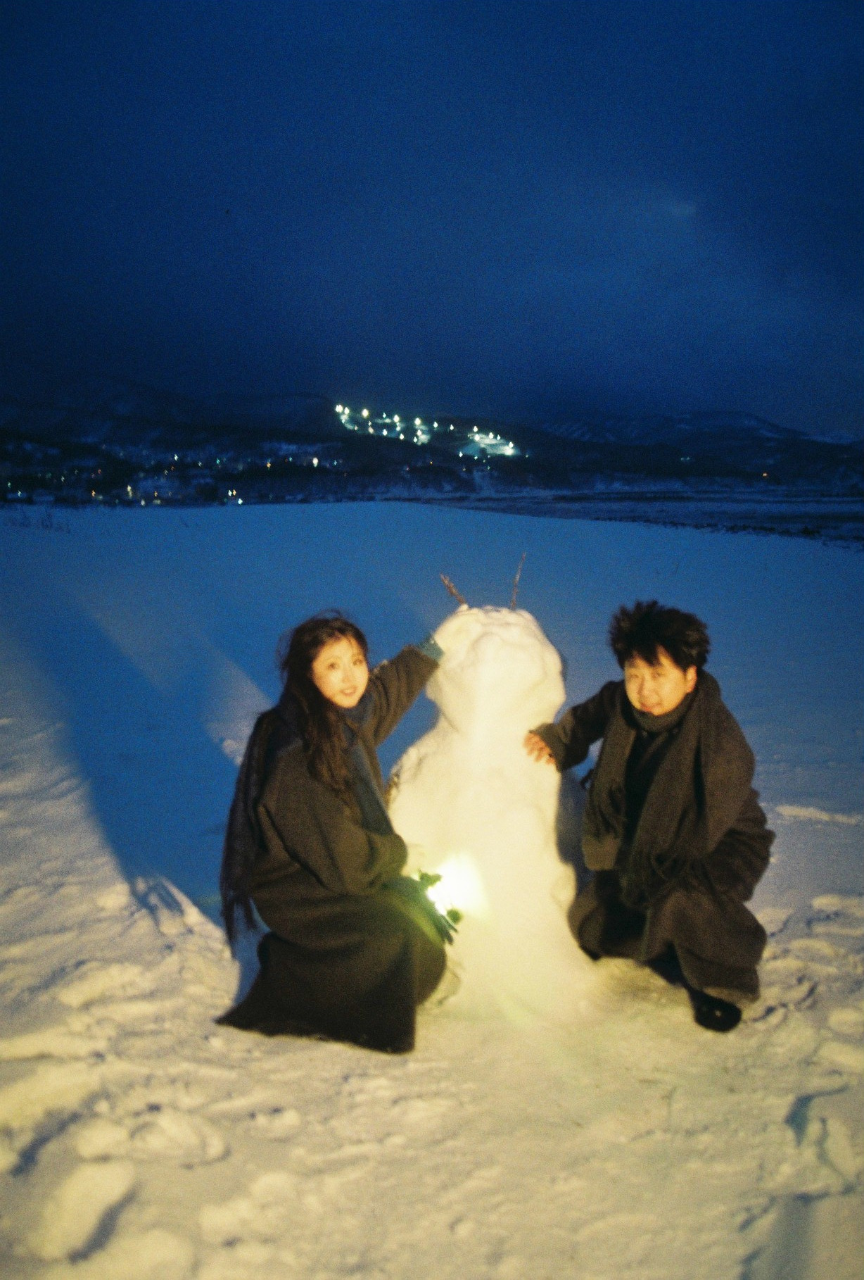 海边雪人旁的两个人