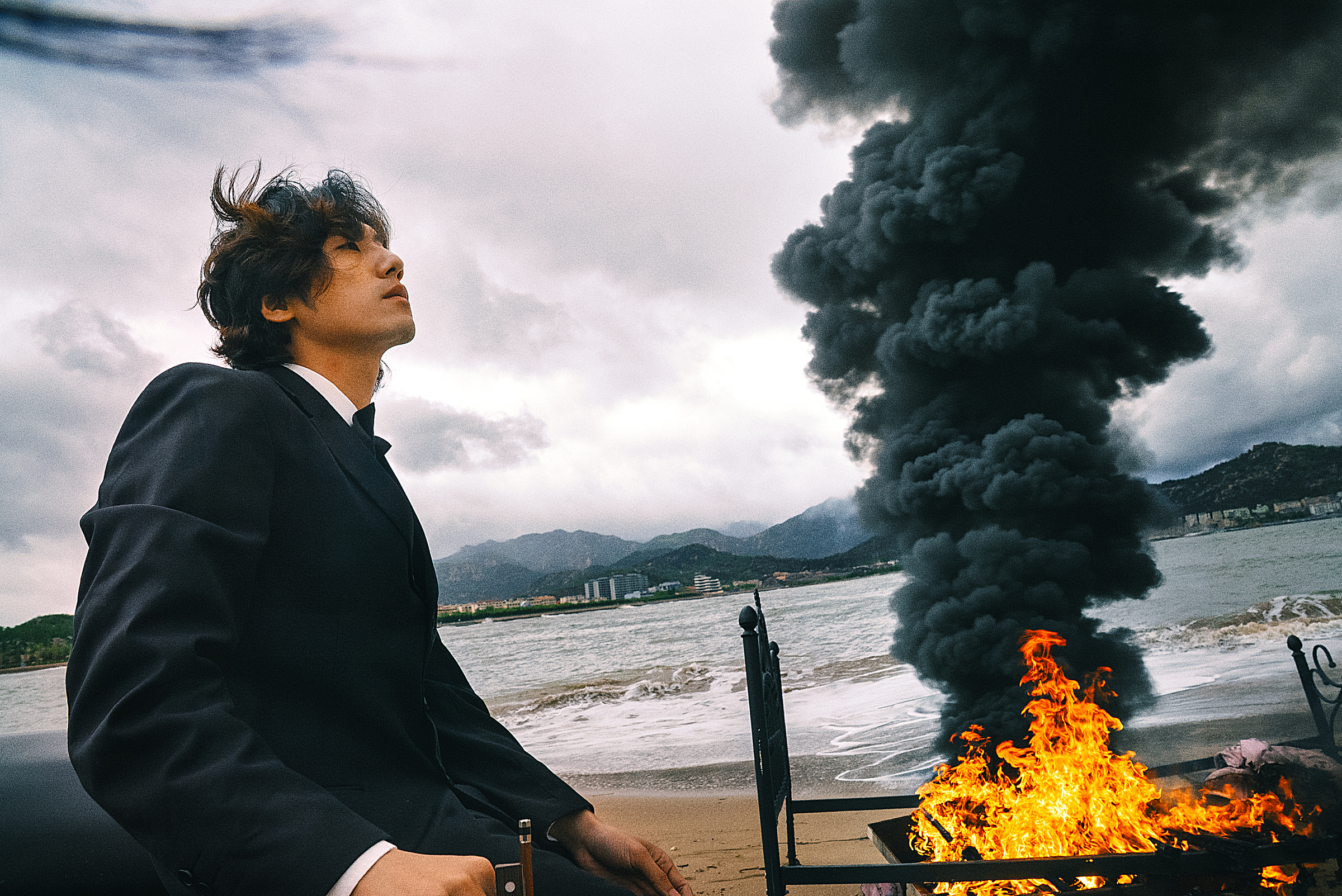 青岛海边烟云背景前的西装男子侧面